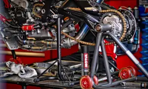 Motocykl na stojaku, gotowy do smarowania łańcucha. Puszka smaru Motul obok.