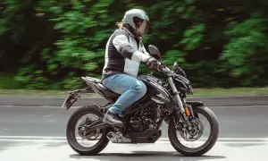 Motocyklista w kasku pędzi na czarnym Romet 125, pokonując kolejne 15 km.