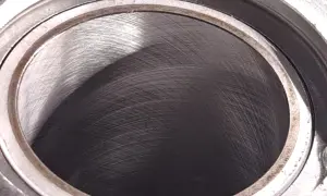 Metalowy cylinder z widocznymi śladami obróbki. Wnętrze, czyli big bore, jest ciemne i lekko błyszczące.