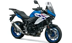 Niebiesko-biały, ekonomiczny motocykl turystyczny Suzuki SV-650X z kufrem na bagaż, gotowy na długie trasy.