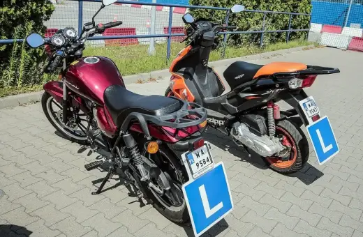 Dwa skutery z literą "L" na tablicach, gotowe do nauki jazdy. Zastanawiasz się, ile kosztują prawo jazdy AM?