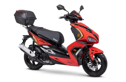 Czerwony skuter Romet z czarnym siedzeniem i kufrem. Idealny do miasta, do jakiej pojemności można jeździć motorem bez prawa jazdy?